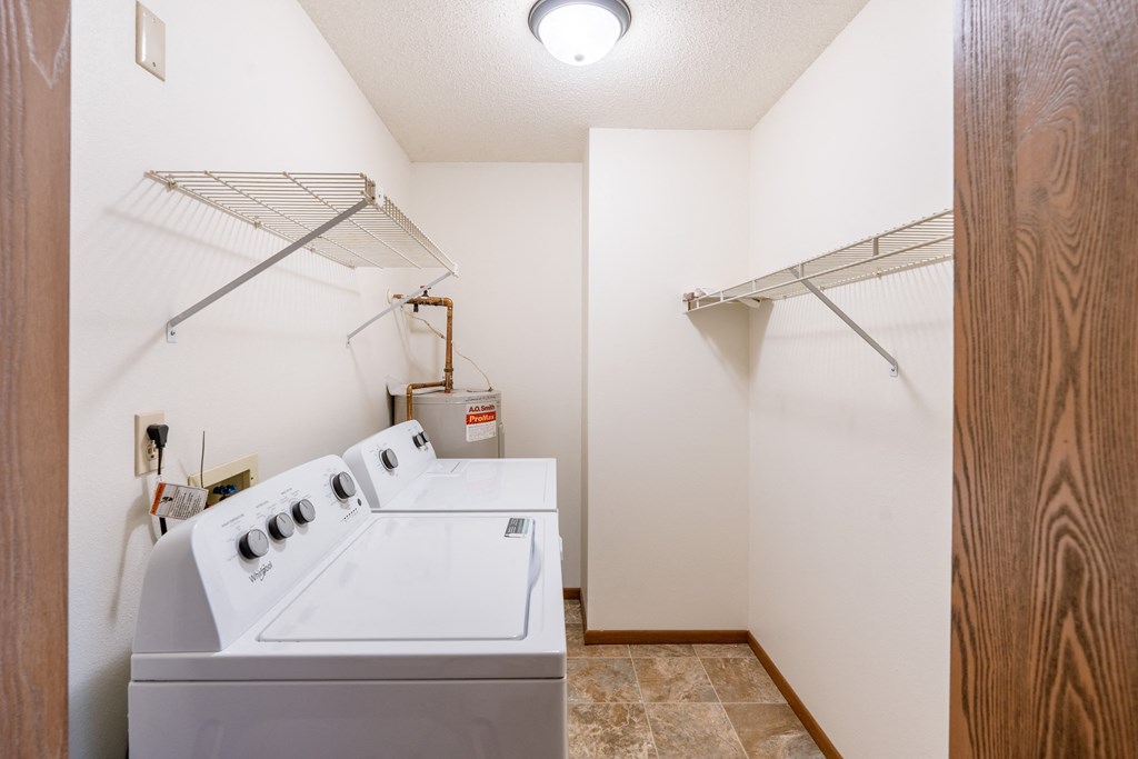 a laundry room with a washer and dryer and a closet. Fargo, ND Auburn II Apartments