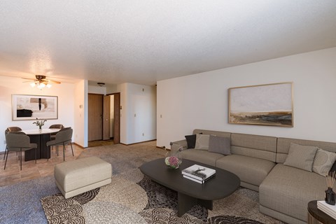 a living room with a couch and a coffee table and a dining room