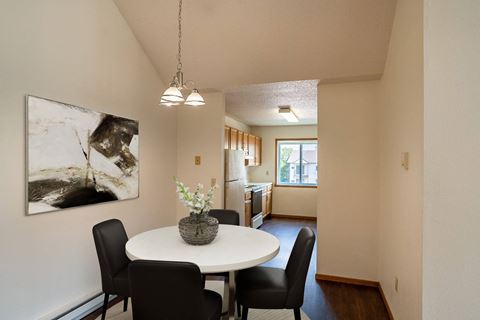 Fargo, ND Bayview Apartments. A dining area with a table and chairs and a kitchen in the background