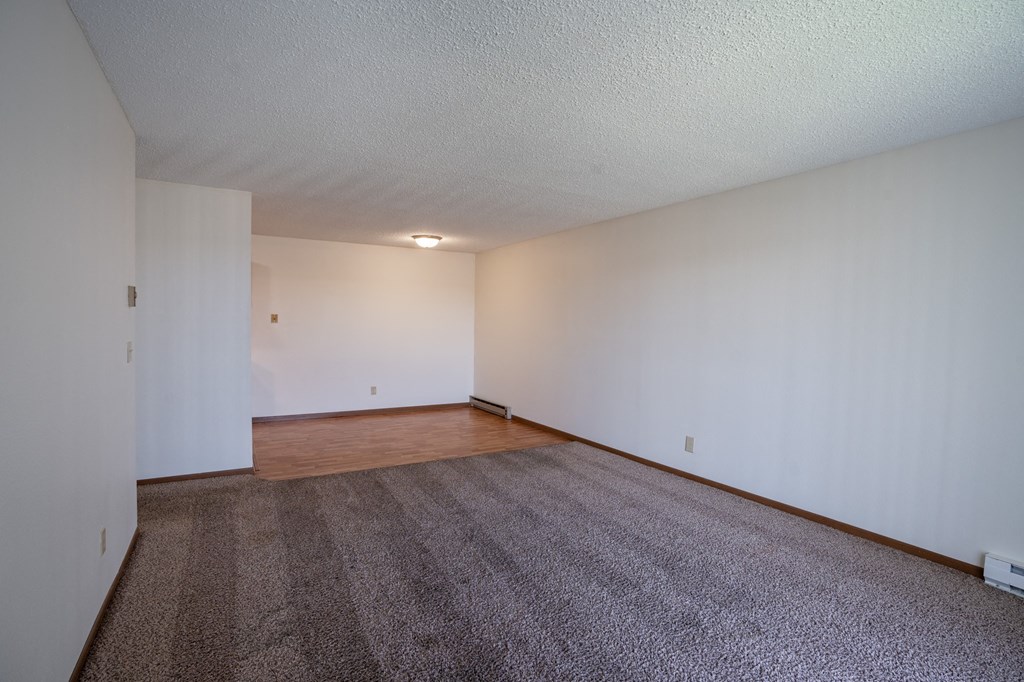 a living room with wood flooring and white walls. Fargo, ND Bella Vista Apartments