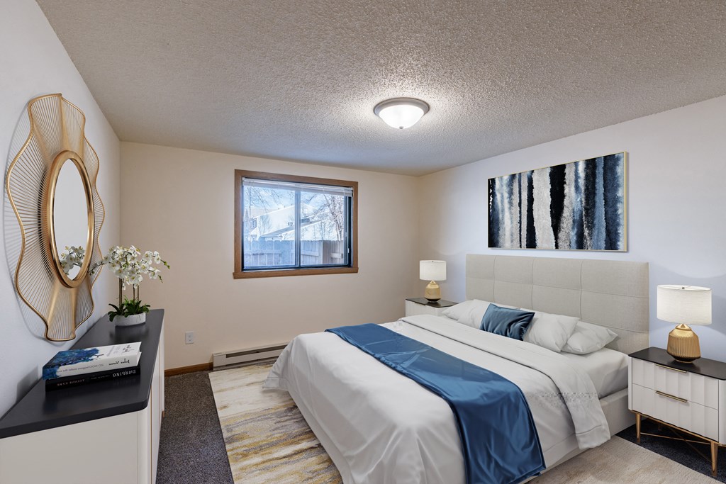 a bedroom with a white bed and a blue blanket. Fargo, ND Berkshire Apartments