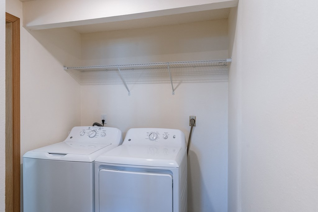 an empty laundry room with  a washer and a dryer. Fargo, ND Berkshire Apartments