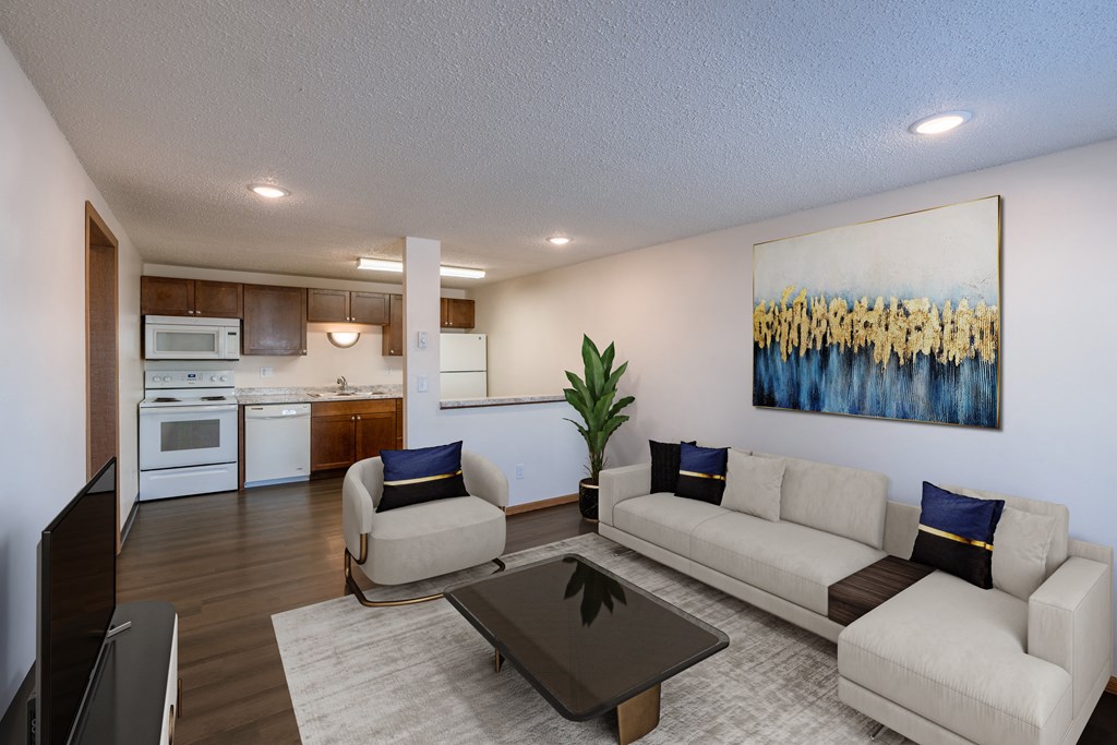 a living room with a couch and a table and a kitchen. Fargo, ND Berkshire Apartments