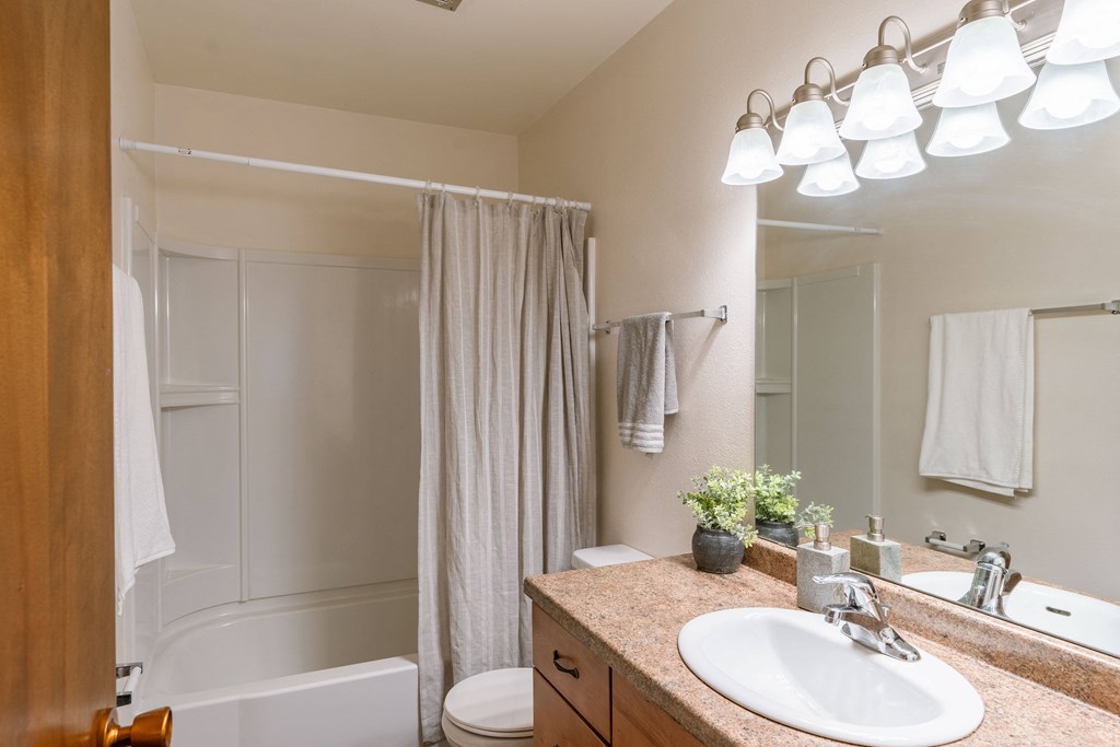 a bathroom with a sink and a shower and a toilet. Fargo, ND Betty Ann Apartments
