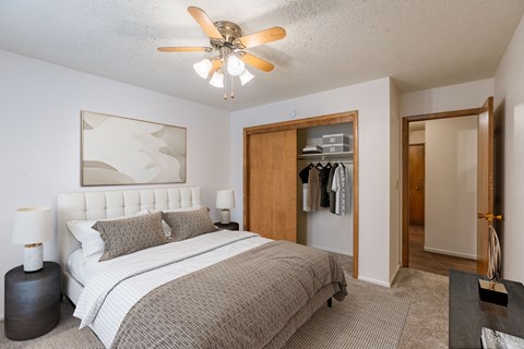 a bedroom with a bed and a ceiling fan. Fargo, ND Betty Ann Apartments