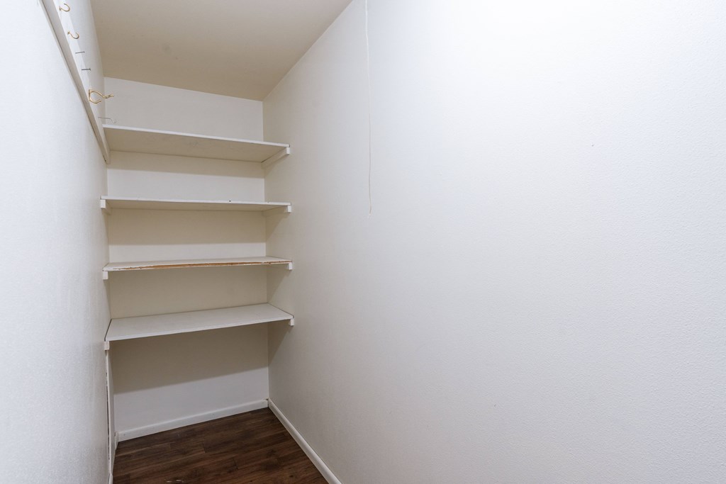 an empty closet in a room with wooden floors and white walls. Fargo, ND Betty Ann Apartments