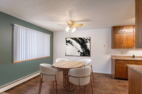 a dining room with a table and chairs and a ceiling fan. Fargo, ND Betty Ann Apartments