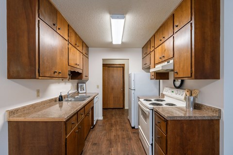 a kitchen with white appliances and wooden cabinets