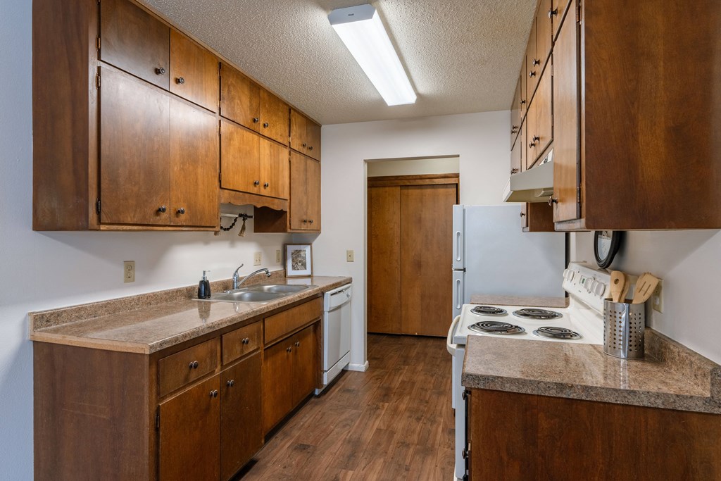a kitchen with a stove and a sink and a refrigerator. Fargo, ND Betty Ann Apartments