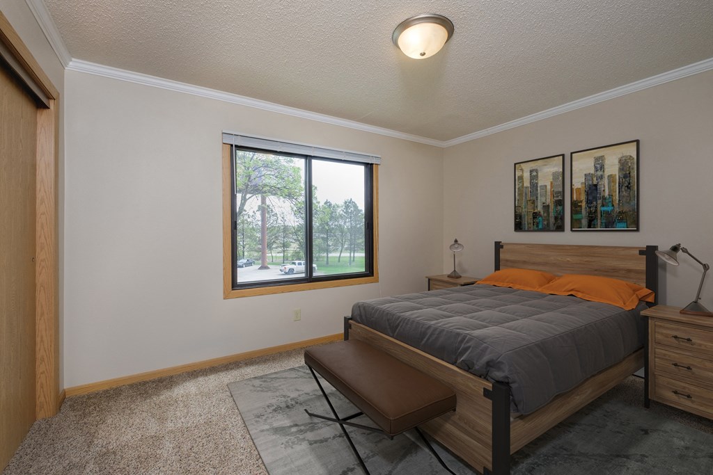 a bedroom with a large window and a large bed. Fargo, ND Birchwood 2 Apartments