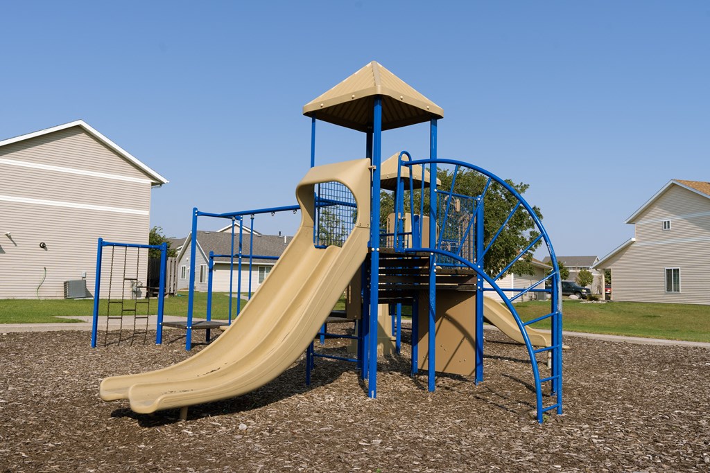 Fargo, ND Bluestem Townhomes| Playground a playground with a slide and a tower. Fargo, ND Bluestem Townhomes