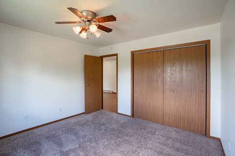 a bedroom with carpet and a ceiling fan. Fargo, ND Briar Pointe Apartments