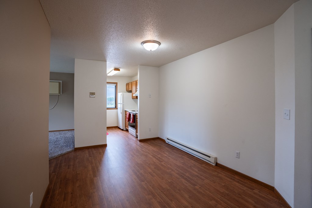 a dining room and kitchen with wood floors and white walls. Fargo, ND Briar Pointe Apartments