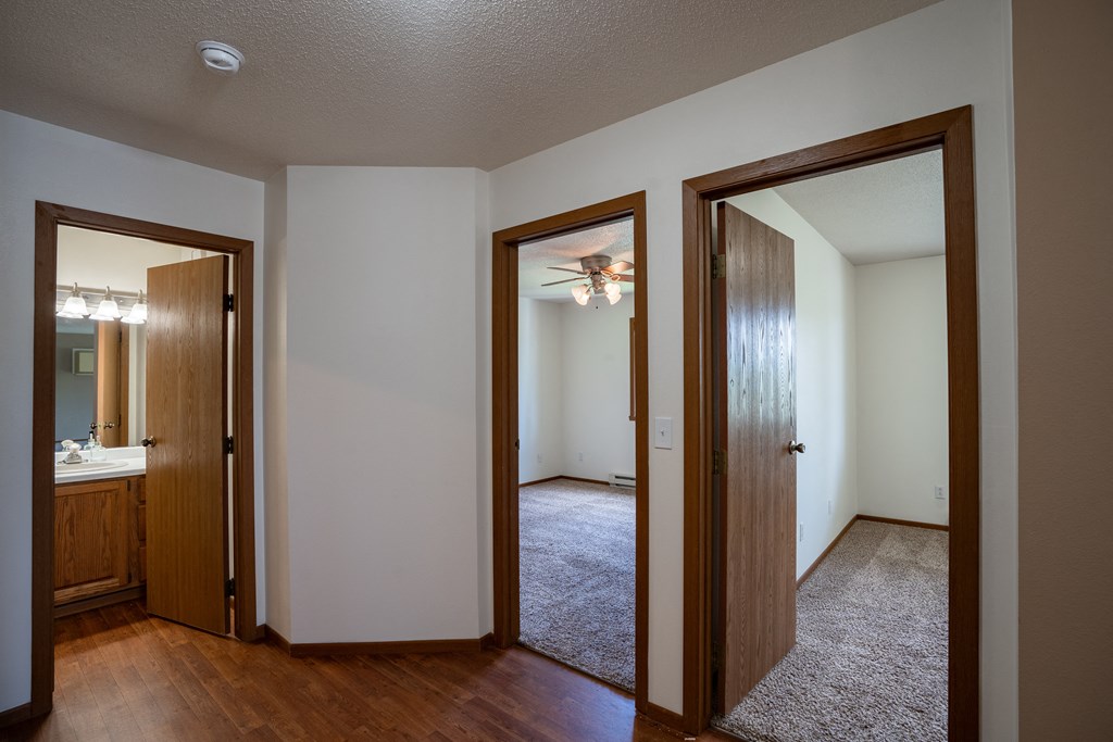 a hallway with two doors into a bedroom and a bathroom. Fargo, ND Briar Pointe Apartments