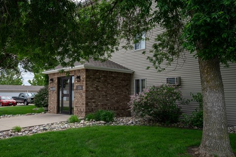 a side view of a house with a tree and a sidewalk. Fargo, ND Briar Pointe Apartments