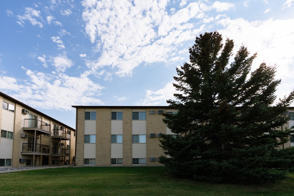 an apartment building with a large tree in front of it. Fargo, ND Brookfield Apartments