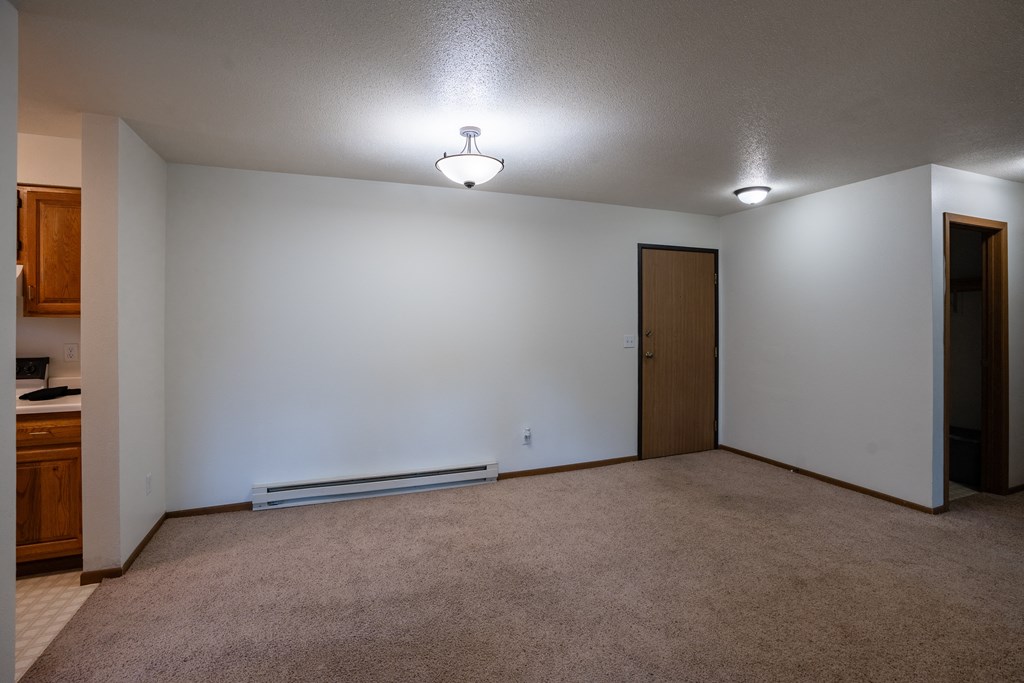 a dining room with a white wall and a door to a closet. Fargo, ND Brownstone Apartments