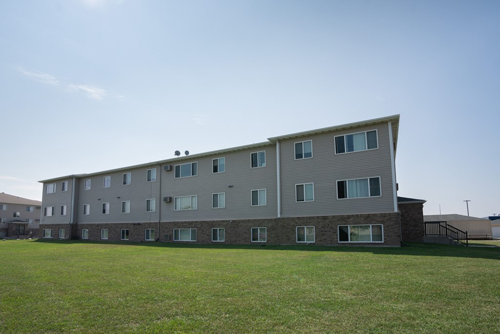 Fargo, ND Cambridge Apartments. A large apartment building with a green lawn in front of it
