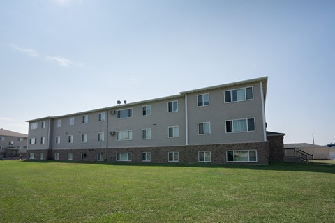 Fargo, ND Cambridge Apartments. A large apartment building with a green lawn in front of it