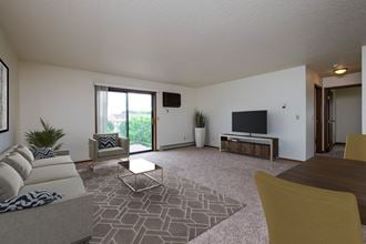 Fargo, ND Carlton Place Apartments. a living room with a couch a table and a tv