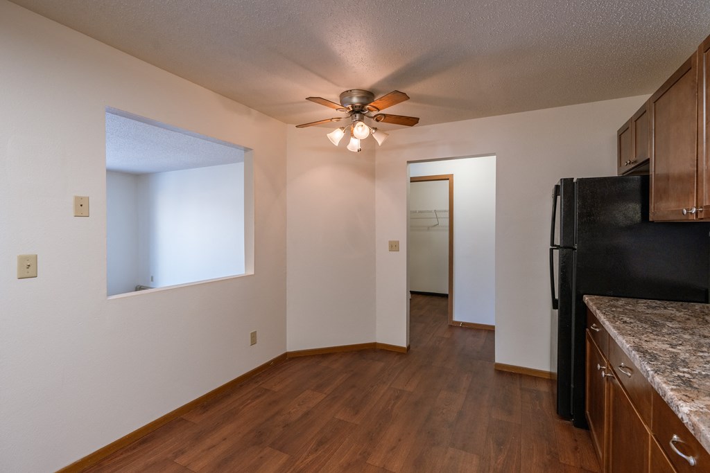 a dining room with a kitchen and a ceiling fan. Fargo, ND Carlton Place Apartments