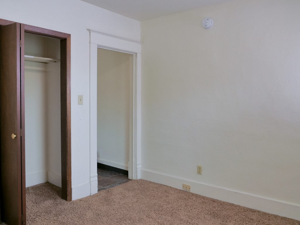 Fargo, ND Cityside Apartments . a bedroom with a door to a closet and a carpeted floor
