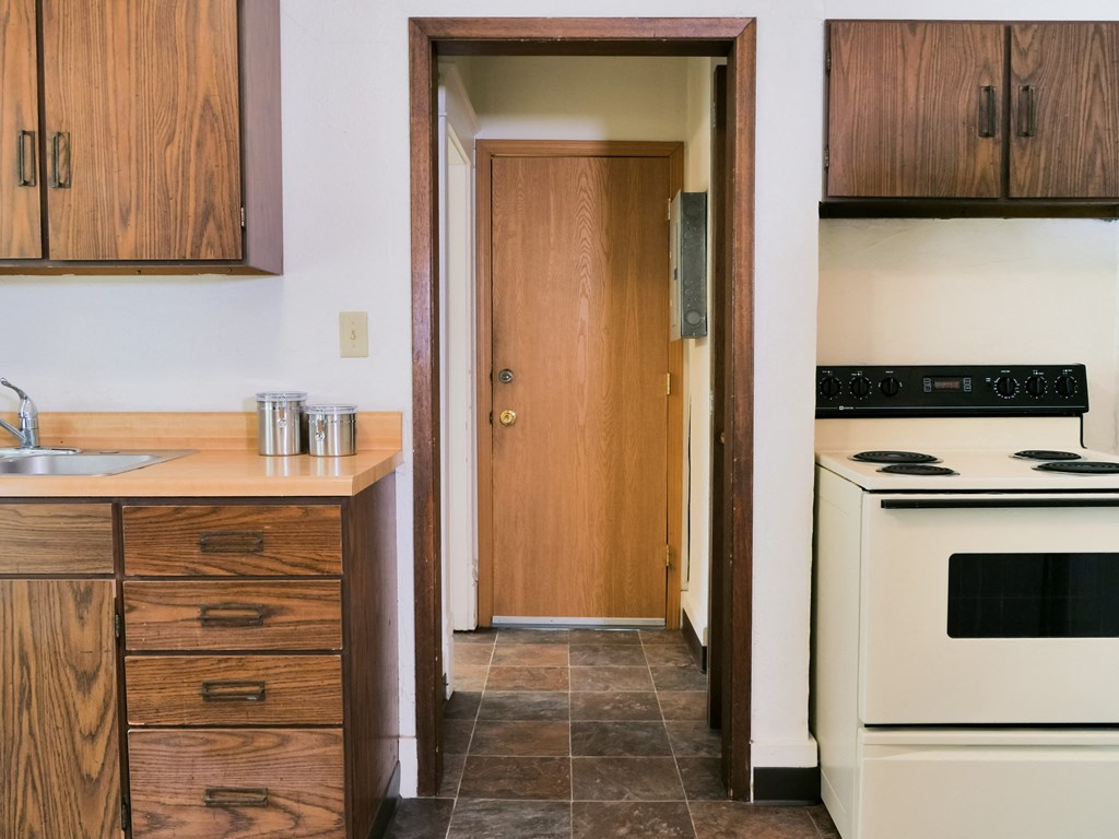a kitchen with a white stove top oven next to a sink