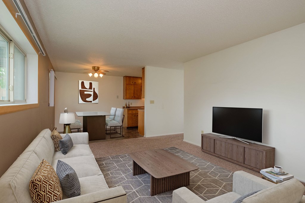 a living room with a couch and a television. Fargo, ND Country Club Apartments