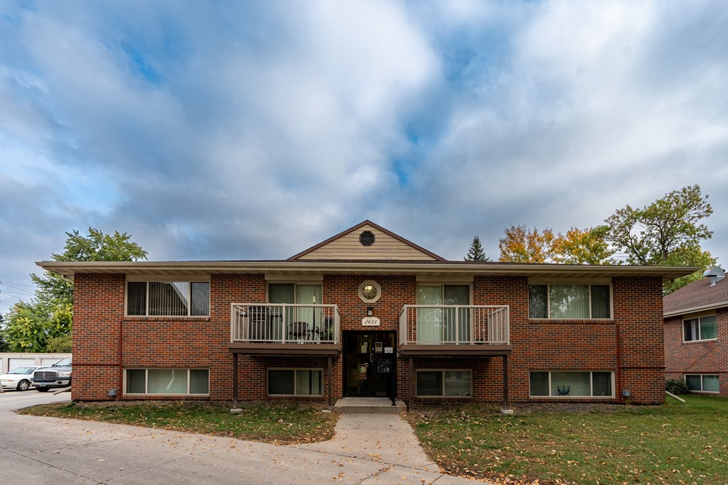 an apartment building with two balconies and a sidewalk. Fargo, ND Country Club Apartments.