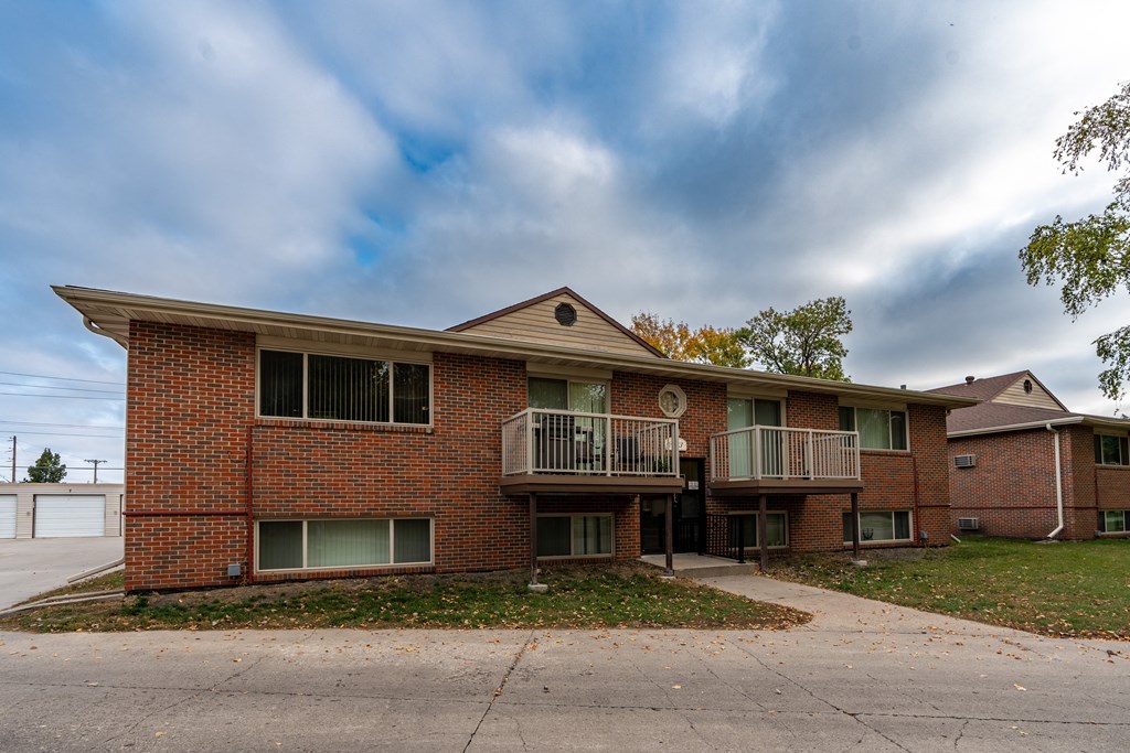 an apartment building with two balconies and a sidewalk