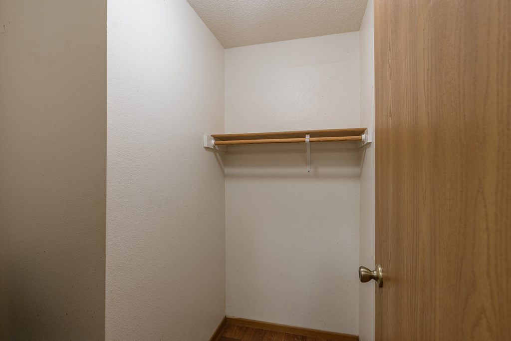 an empty closet in a room with a wooden door. Fargo, ND Country Edge Apartments