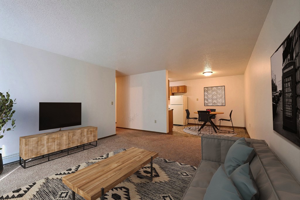 the living room of an apartment with a couch and a tv. Fargo, ND Country Edge Apartments
