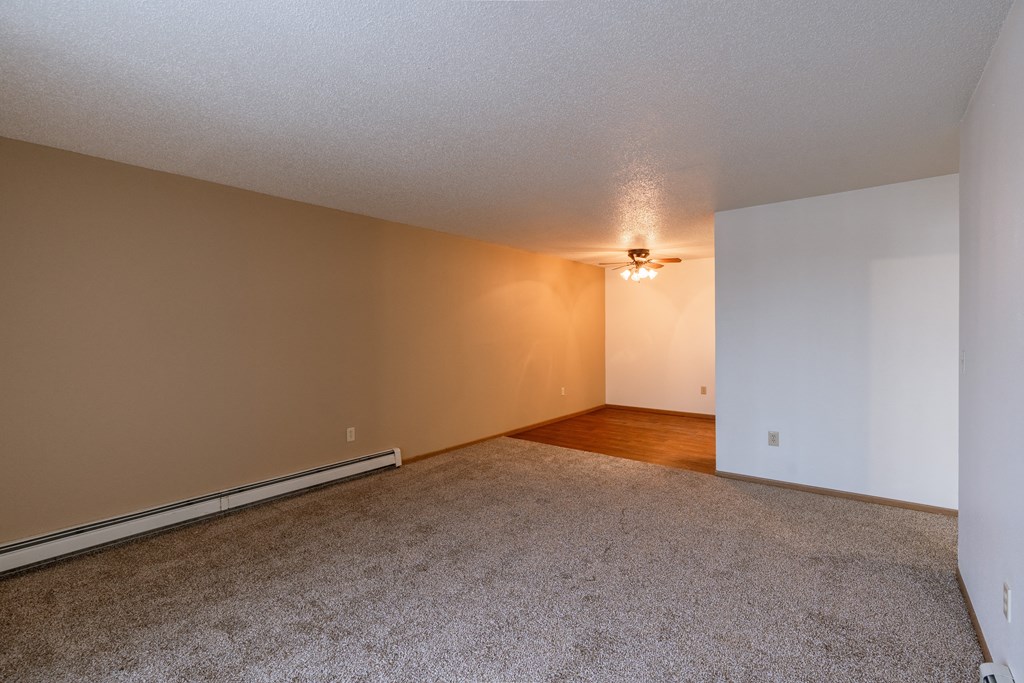 the living room and dining room of an empty apartment. Fargo, ND Country Edge Apartments