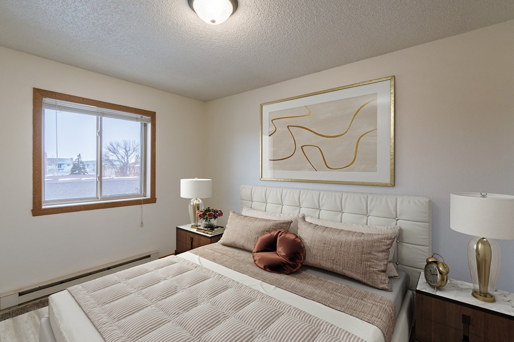a bedroom with a bed and a window. Fargo, ND Crescent Park Apartments