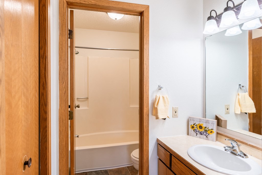 a bathroom with a sink and a shower and a mirror. Fargo, ND Crescent Park Apartments