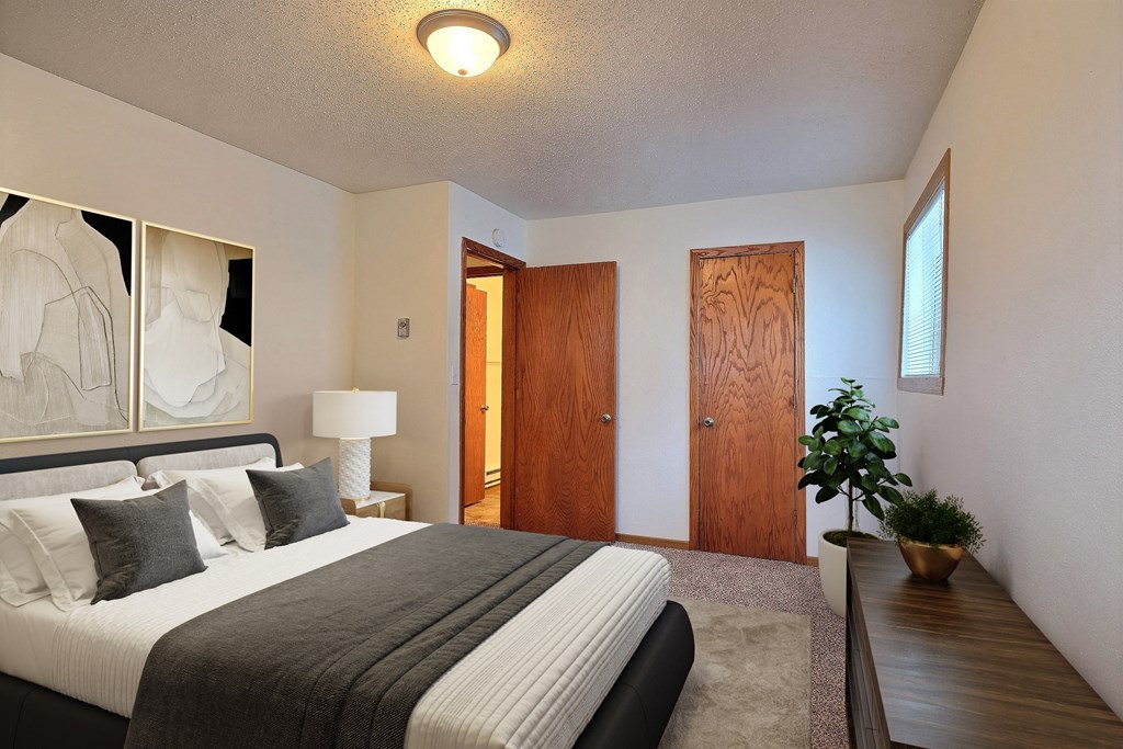 Fargo, ND Dakota Manor Apartments. a bedroom with a bed and a desk in a room