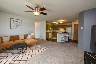 Fargo, ND Danbury Apartments. a living room with a couch a table and a ceiling fan