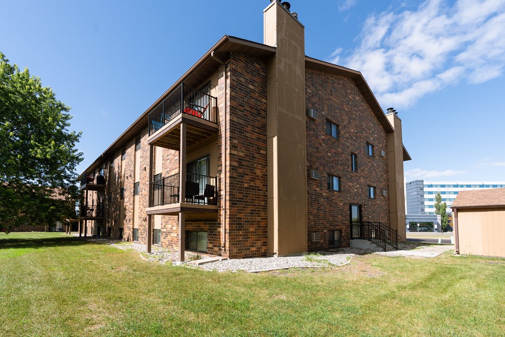 Fargo, ND Dynasty Apartments. a view of the back of the building with a blue sky in the background