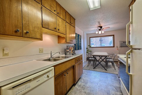 a kitchen with a sink and dishwasher and a table with chairs