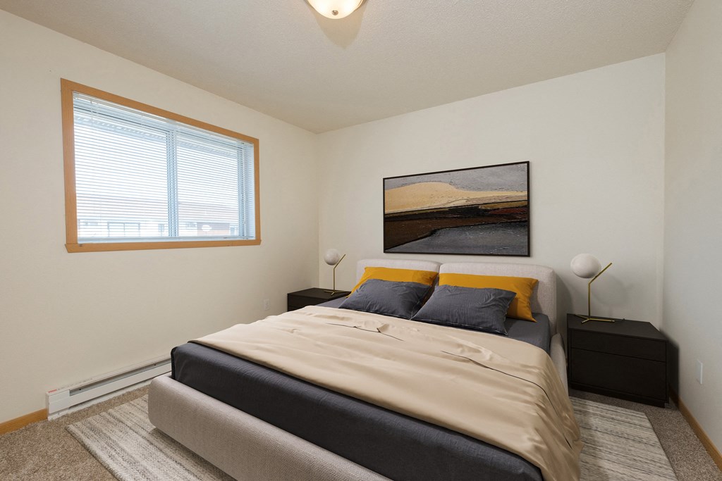 Fargo, ND Essex Apartments. A bedroom with a large window. The room features a comfortable bed, stylish furnishings, and soft lighting, creating a relaxing and peaceful atmosphere.
