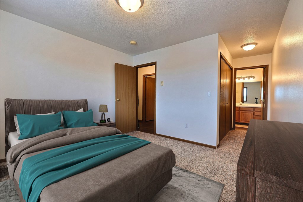 Fargo, ND Flagstone Apartments. a bedroom with a bed and a dresser