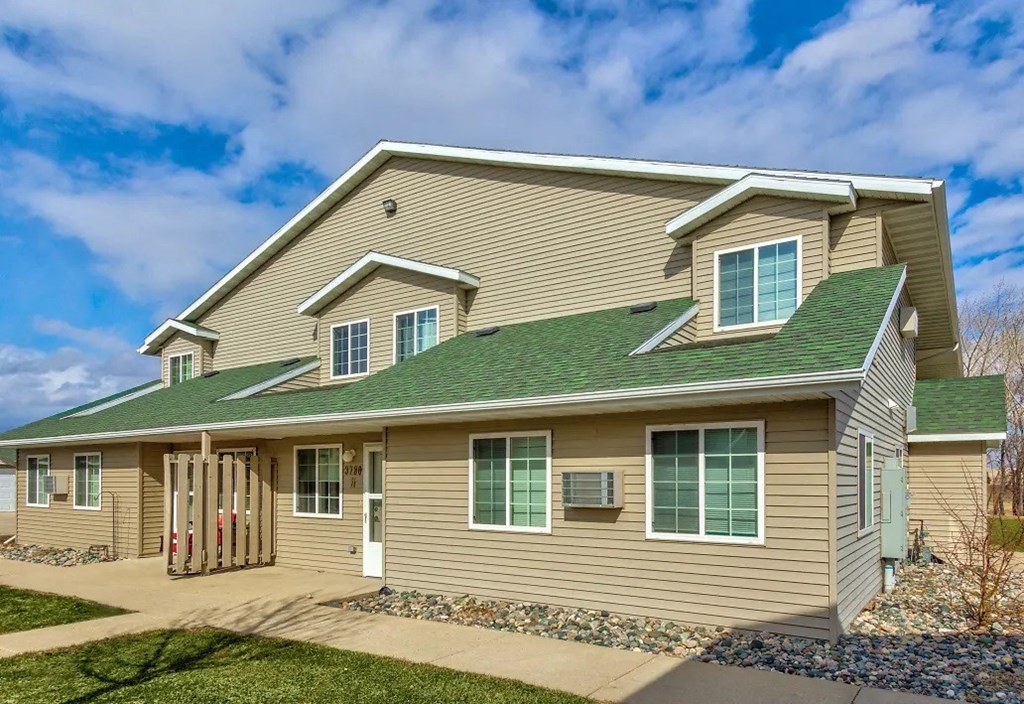 a house with a green roof and a sidewalk. Fargo, ND Foxtail Townhomes