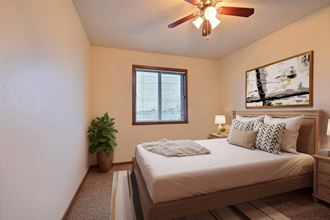 Fargo, ND France Apartments. a bedroom with a large bed and a ceiling fan