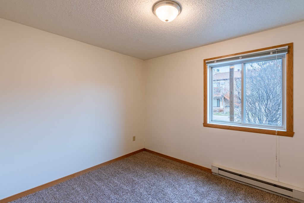 a bedroom of an empty house with a large window