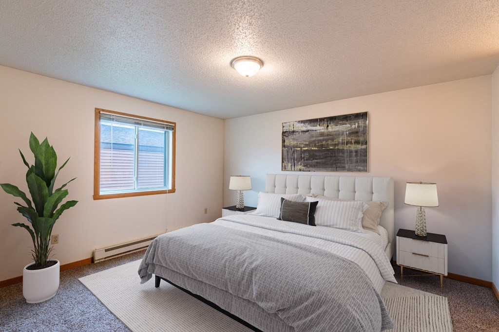 Fargo, ND Galleria 3 Apartments | Bedroom a bedroom with a bed and a potted plant. Fargo, ND Galleria 3 Apartments