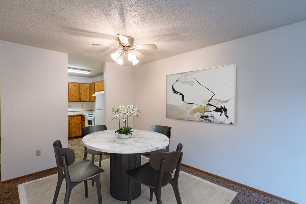 Fargo, ND Galleria 3 Apartments | Dining a dining room with a table and chairs and a ceiling fan. Fargo, ND Galleria 3 Apartments