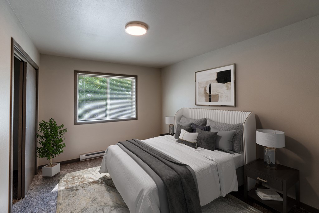 a bedroom with a large bed and a window. Fargo, ND Granger Court Apartments