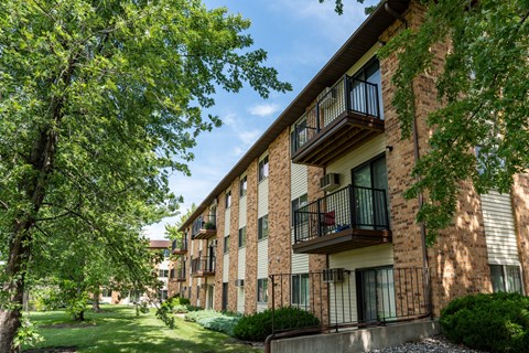 Exterior view of a brick apartment building with balconies. Fargo, ND Granger Court Apartments.