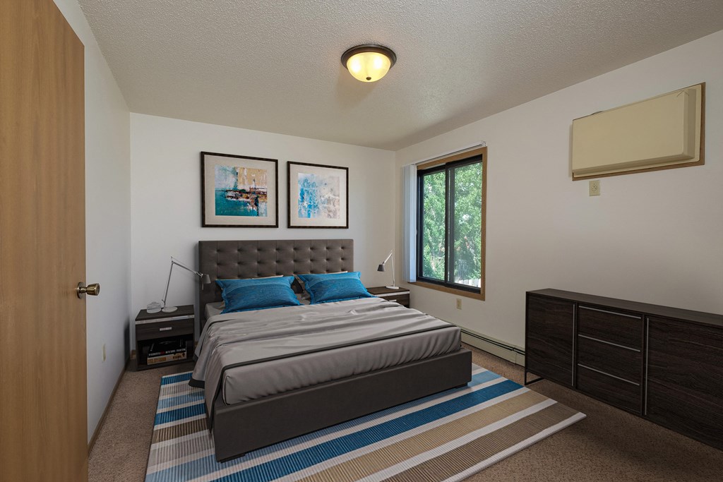a bedroom with a bed and two dressers. Fargo, ND Hazelwood Townhomes