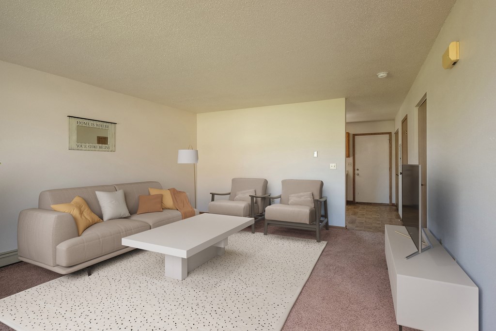 a living room with a couch and chairs and a coffee table. Fargo, ND Hazelwood Townhomes
